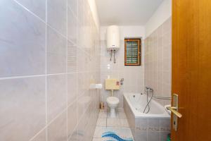 Un baño con bañera, inodoro y lavabo. en Dodo Sea View Apartments, en Novalja