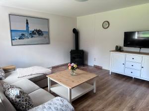 a living room with a couch and a table with a fireplace at Landhäuschen Danneborth in Danneborth