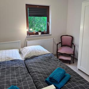 Un dormitorio con una cama y una silla y una ventana. en Landhäuschen Danneborth, en Danneborth