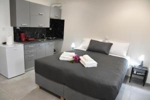 a bedroom with a bed with towels and flowers on it at Aloha Inn in Artemida +41 photos