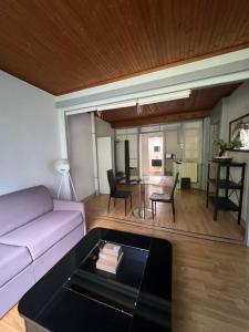 a living room with a couch and a table at Grand studio tout confort sur cour in Champagnole