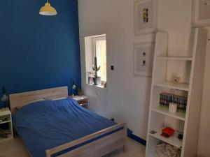 une chambre avec un lit avec un mur bleu dans l'établissement Belle villa avec piscine proche d Aix en provence, à Cabriès