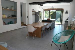 une cuisine avec une grande table et des chaises en bois dans l'établissement Belle villa avec piscine proche d Aix en provence, à Cabriès