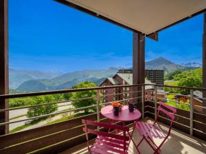 a table and chairs on a balcony with a view of mountains at Apartment Bâtiment A-18 by Interhome in Le Corbier
