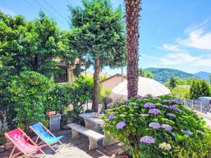 a patio with chairs and a bench and flowers at Holiday Home Casa Naima by Interhome in Breno