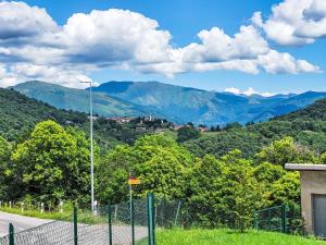 a fence on a road with mountains in the background at Holiday Home Casa Naima by Interhome in Breno