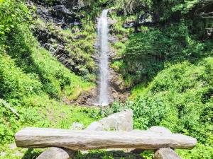 a wooden bench sitting in front of a waterfall at Holiday Home Casa Naima by Interhome in Breno +21 photos