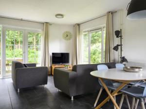 a living room with a table and chairs at Holiday Home Bungalowpark It Wiid by Interhome in Eernewoude