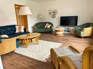 ein Wohnzimmer mit Sofas, Tisch und Fernseher in der Unterkunft Ferienhaus Fiete 2 in Sagard