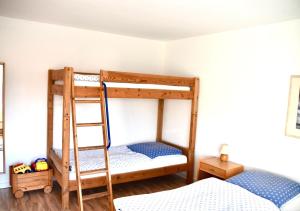 2 Etagenbetten in einem Zimmer mit einer Leiter in der Unterkunft Ferienhaus Fiete 2 in Sagard