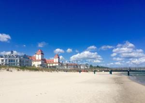 Blick auf einen Strand mit einem Pier und Gebäuden in der Unterkunft Ferienhaus Fiete 2 in Sagard