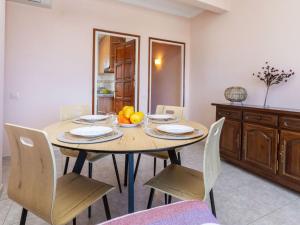 a dining room with a wooden table and chairs at Apartment Fénix Marina by Interhome in L'Escala +18 photos