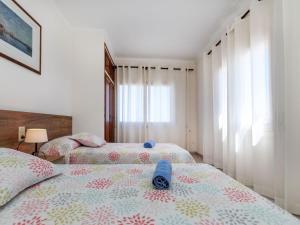 two twin beds in a room with a window at Apartment Fénix Marina by Interhome in L'Escala