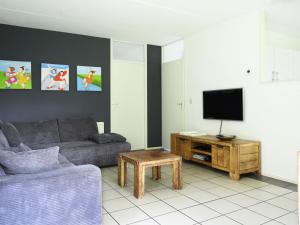 ein Wohnzimmer mit Sofa und Fernseher in der Unterkunft Holiday Home Bungalowpark It Wiid by Interhome in Eernewoude