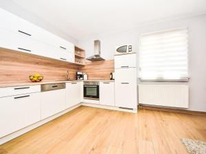 a kitchen with white cabinets and a wooden floor at Holiday Home Anić by Interhome in Smilčić +27 photos