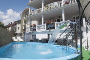 a pool with a water slide in front of a building at Hotel Kralj in Vrnjačka Banja