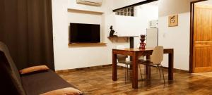 a living room with a table and a tv at Appartement charmant près d'Orange avec piscine partagée in Orange