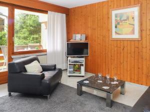 un soggiorno con un divano in pelle e una televisione di Apartment Vert Pré 2 by Interhome a Verbier