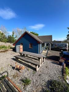 a blue building with a bench and a house at Radio Skye Pods in Portree