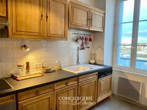a kitchen with wooden cabinets and a sink at La Passerelle in Cherbourg en Cotentin