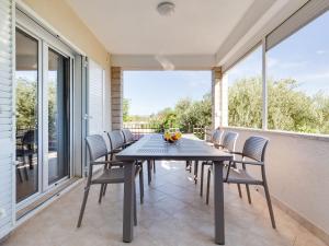a dining room with a table and chairs on a balcony at Holiday Home Relax by Interhome in Jasenice +67 photos