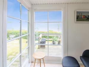 a room with a window and a table and chairs at Holiday Home Fabine - 50m from the sea by Interhome in Allinge +20 photos
