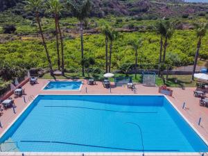 an overhead view of a swimming pool with palm trees at Casa Villalba - Appartamento con piscina in Santa Tecla