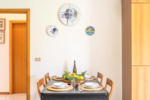 a dining room table with chairs and plates on the wall at Casa Villalba - Appartamento con piscina in Santa Tecla