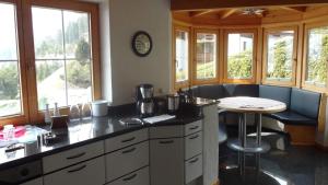 una cucina con bancone e tavolo e alcune finestre di Ferienhaus Achensee in Achenkirch ad Achenkirch
