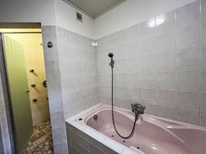 a bathroom with a pink tub and a shower at Studio The Green Studio by Interhome in Stein an der Enns +19 photos
