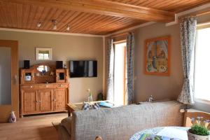 a living room with a couch and a tv at Charmant trifft Moderne - Ferienwohnung Linde in Spalt