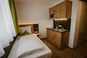 a small bedroom with a bed and a sink at Motel Sleep Inn in Töging am Inn
