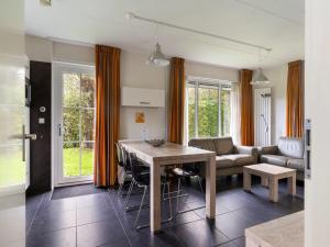 a living room with a table and a couch at Holiday Home Bungalowpark It Wiid by Interhome in Eernewoude