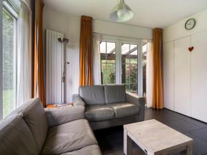 a living room with a couch and a table at Holiday Home Bungalowpark It Wiid by Interhome in Eernewoude