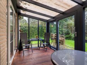 a screened in porch with a table and chairs at Holiday Home Bungalowpark It Wiid by Interhome in Eernewoude