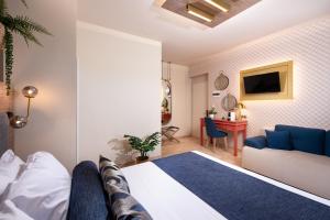 a hotel room with a bed and a couch at ELLE Rooms & Suites in Paralia Katerinis