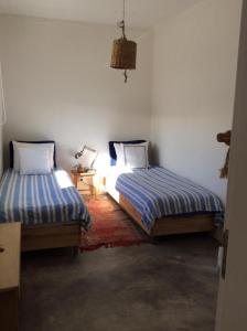 a bedroom with two beds and a table with a lamp at Comporta Cottage in Montevil +2 photos