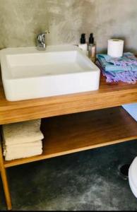 a white sink on top of a wooden shelf at Comporta Cottage in Montevil