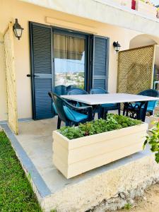 a table and chairs on the patio of a house at Terpsichori villa and apartments in Kalamaki