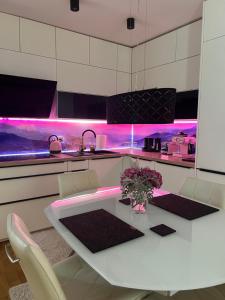 a kitchen with a white table and pink lighting at Apartment Anaa in Radovljica