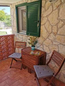 un patio con 2 sedie, un tavolo e una finestra di Argentario Cottage a Giannella Altre 26 foto