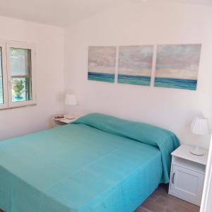 una camera da letto con un letto e due quadri sul muro di Argentario Cottage a Giannella