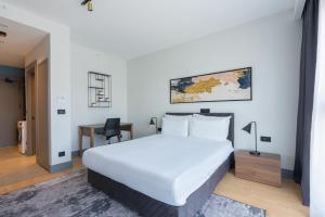 伊斯坦布尔The Superior Living Kağıthane的卧室里有一张白色的大床和一张书桌