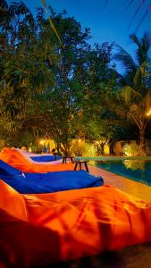 a row of mattresses lined up next to a swimming pool at Richards Cabanas in Tissamaharama