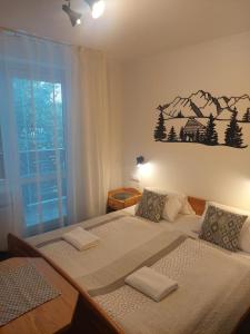 a bedroom with two beds and a mountain mural on the wall at vila Happy in Veľká Lomnica
