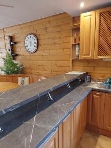 a kitchen with a counter with a clock on the wall at vila Happy in Veľká Lomnica +54 photos