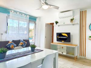 Una sala de estar con una mesa y un televisor. en Apartamentos Casanostra, en Salou
