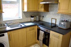 a kitchen with a sink and a counter top at Spacious 2 Bed Flat - 5 mins to St Helens Centre - Free Parking in Saint Helens