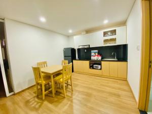 a kitchen and dining room with a table and chairs at Happy House Apartment in Da Nang