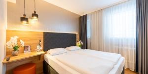 Ліжко або ліжка в номері PLAZA INN Rieker Stuttgart Hauptbahnhof